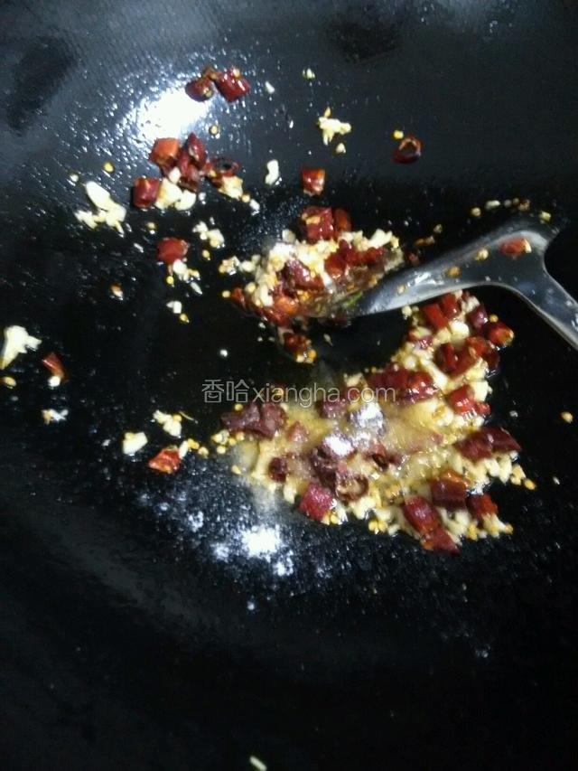 放入干椒段跟蒜末一起爆香，放入一勺盐炒匀。