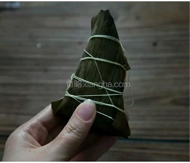 拉一根线，用力绕几圈在粽子上，包紧。