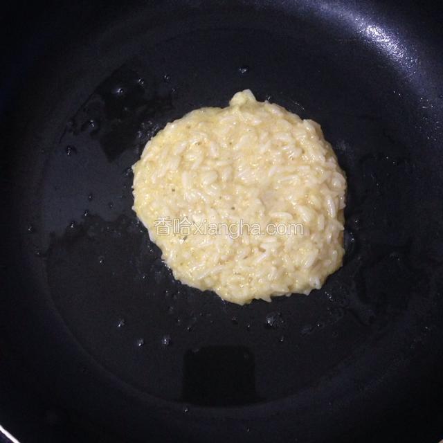 起不粘锅放入少许油，舀一勺米饭糊摊在上面，煎一面到一面