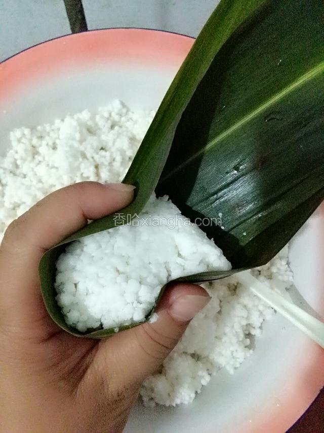 用左手的拇指和食指按下上面的粽叶