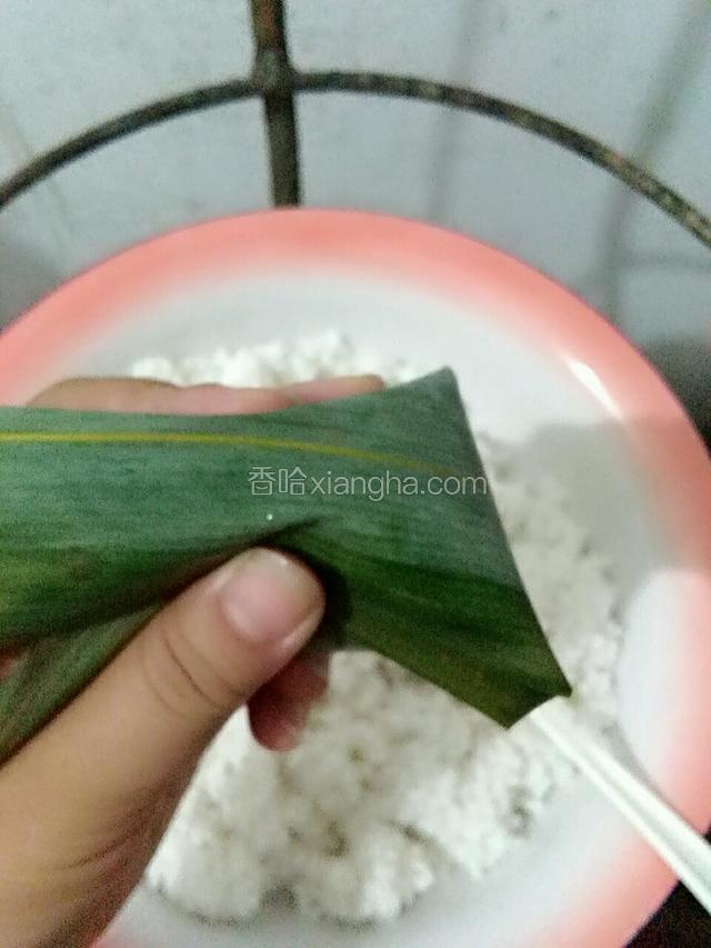 将上面的粽叶盖下来，捏紧
