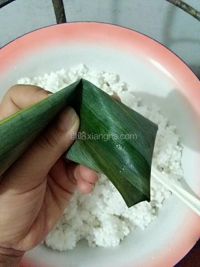 将捏紧的粽叶对折