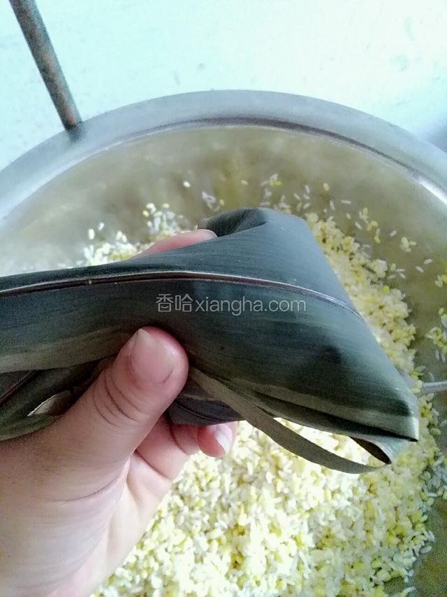 在把粽叶往下盖住
