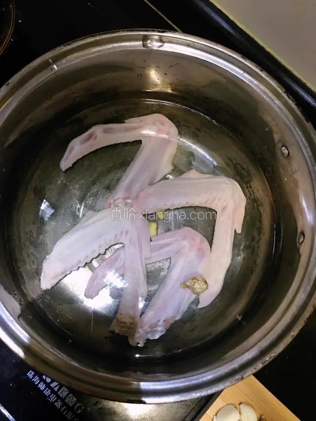 锅内加入适量清水放盐姜片和料酒将鸭翅煮15分钟后捞出洗净血末沥干待用