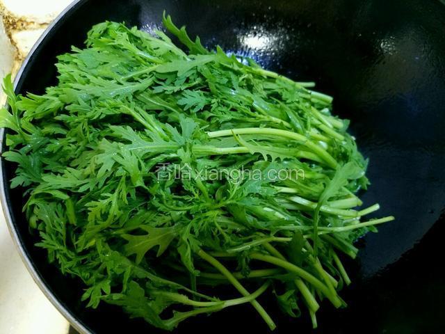 将茼蒿杆的部分先下入锅中进行翻炒。