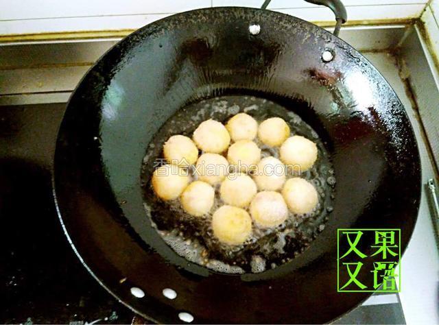 起锅烧油至7层热下入裹满面包糠的丸子开始小火慢炸。