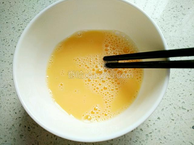 鸡蛋磕入净碗中、加半汤勺温开水、几滴料酒捣散、调匀。