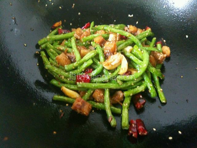 然后放入咸鱼和豆角一起翻炒，同时放入少许盐，添点儿水稍微煮一下，让盐有个融化的过程。这样更方便豆角入味。水快煮干时出锅。