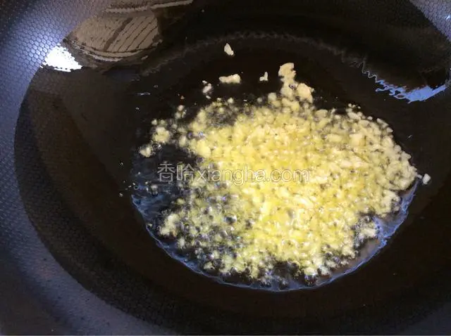 关小火倒入蒜蓉煸炒出蒜的香味。