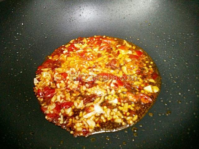 锅里留油，加入豆瓣酱小火炒出红油后，加入姜粒、蒜粒、泡红椒炒出香味。