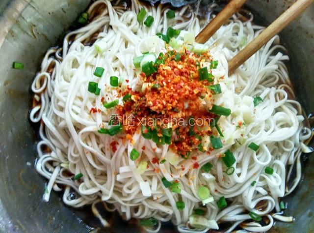 面煮熟后，放入调料碗中，上面放入葱，蒜和辣椒面