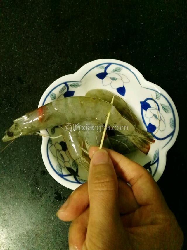 将用牙签插入青虾倒数第二节位置，轻轻的挑出虾线
