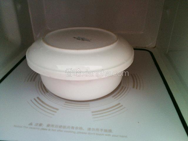 将蛋糕糊放入微波炉中，用一个可以放入微波炉的盖子盖住蛋糕糊。