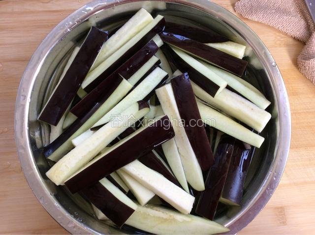 切成条状，放入盆中接满清水侵泡出茄子里的黑水。