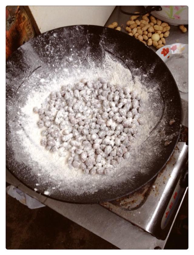 均匀的撒上面粉小火翻炒，每颗花生都粘上面粉即可。