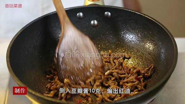 待肉丝炒至棕红色时，倒入10克豆瓣酱，煸出红油后