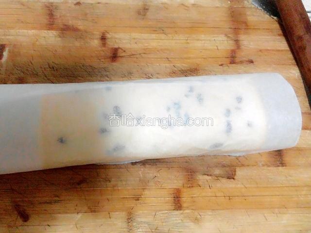 用擀面杖辅助油纸把蛋糕卷起，放冰箱冷藏20分钟定型。