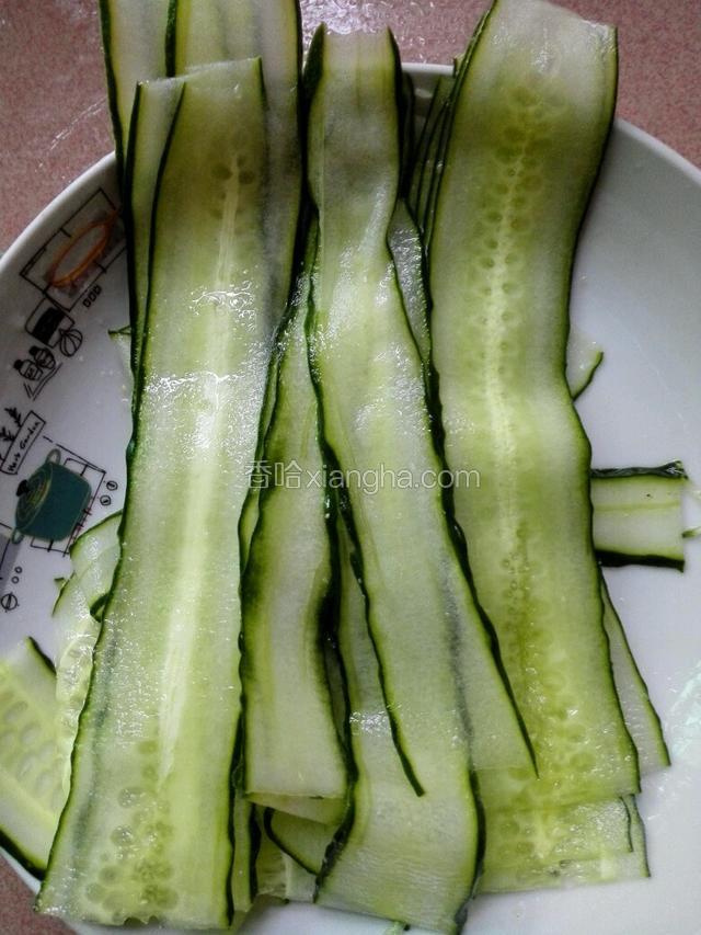 用削瓜刀把黄瓜用暗力慢慢削成薄片条。
