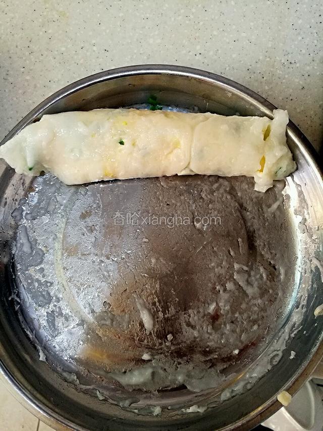 这是已经蒸好的肠粉，然后用刮板顺着一边卷起来。我家没有刮板，但使用的铲子刮的，所以刮出来没那么好看。