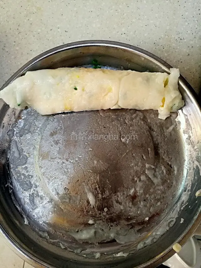 这是已经蒸好的肠粉，然后用刮板顺着一边卷起来。我家没有刮板，但使用的铲子刮的，所以刮出来没那么好看。