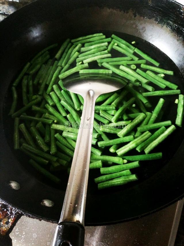 锅里加水烧开，把洗干净的豆角放进去断生（豆角一定要煮熟了，也要避免煮过了）