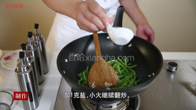 锅中再加2汤匙油，待油温加热至7成热时，放入葱姜进行爆香，放入青椒丝、1g盐，小火继续翻炒。