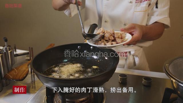 热锅下油大火烧至六成热，下入腌好的肉丁滑熟，捞出备用。