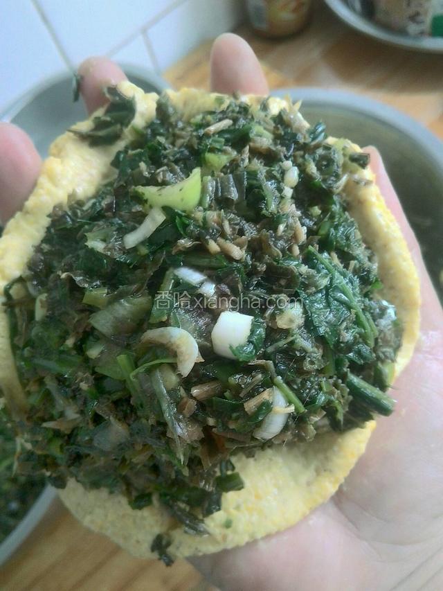 左手用勺子盛陷，放在玉米面上，陷要多些。
