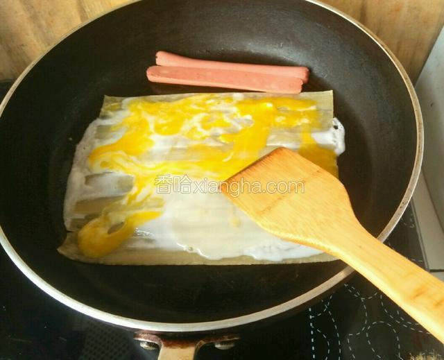 刷过水之后将鸡蛋打在冷面上，用铲子将鸡蛋铺均匀