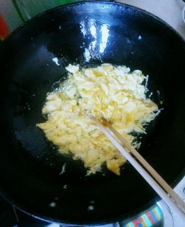 锅中油热后，将鸡蛋打散倒入锅中炒成块状，盛出备用。