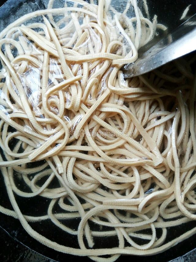 锅里烧开水，下千张煮熟，捞出备用。