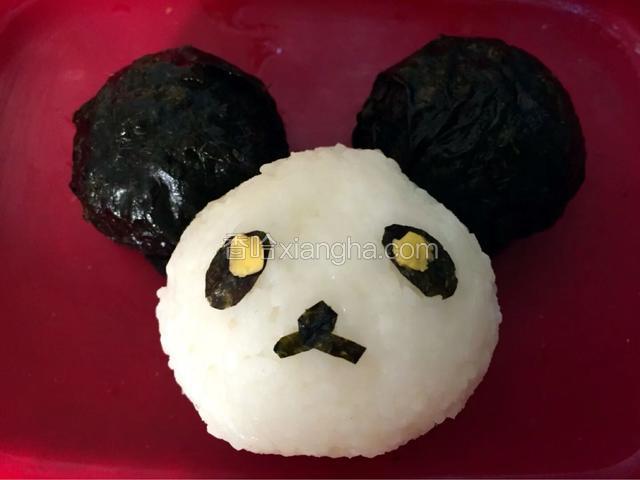 制作一个圆形饭团做熊猫的头，海苔剪出眼睛和鼻子，芝士片装饰眼睛
做两个小的圆形饭团把海苔打湿包裹住饭团做耳朵
