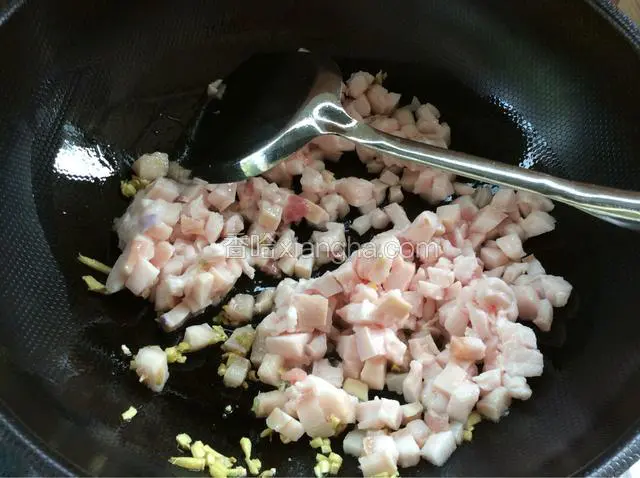 姜末炒金黄后下入肥肉煸炒出油。