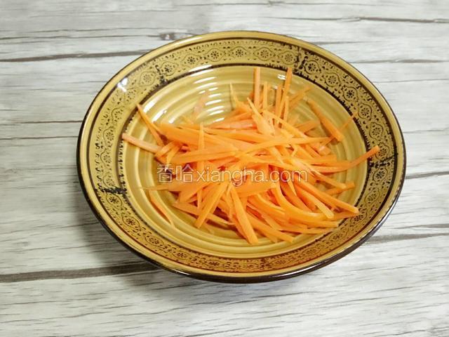 胡萝卜洗干净切成细丝，在锅里焯水控干水捞出来装入碗里备用。