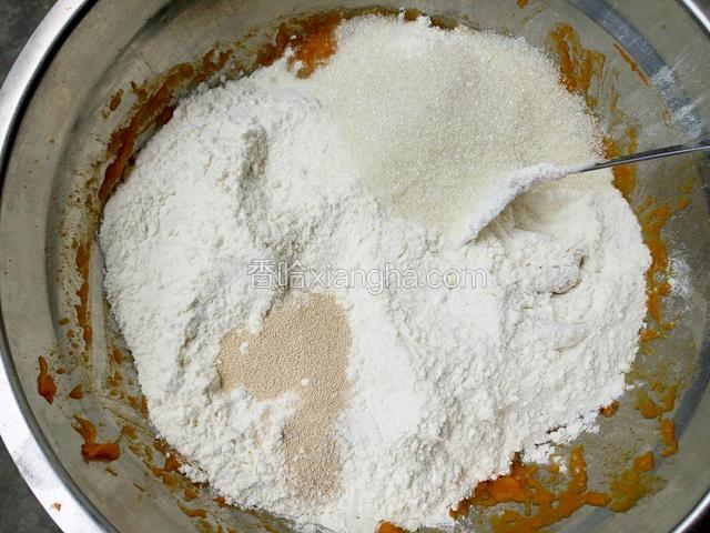 放置晾凉至手温，在南瓜泥上倒入面粉，酵母和少许白糖。（南瓜本身有甜味，白糖的量酌情增减）
