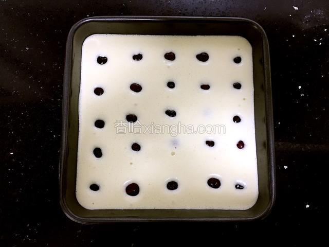 黄油放入一个小碗用微波炉加热溶化，倒入面糊中搅拌均匀，将面糊倒入模具，然后把樱桃一粒粒填入。