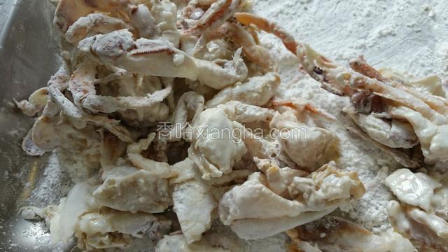 将螃蟹清洗干净后切开、沾上干玉米淀粉，用色拉油炸熟。