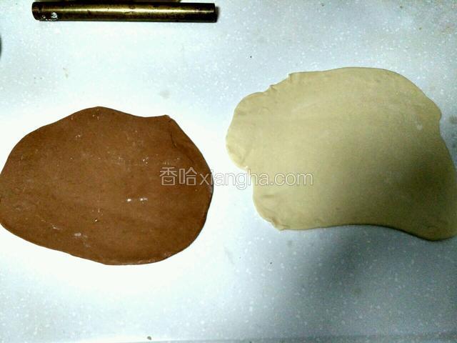 擀成两块差不多大的长方形的面片。自己吃边角不太规则我也不修了，白色面片在下边，稍微用手抹一点水在白面片上，然后将可可的面片放在白色面片上面。