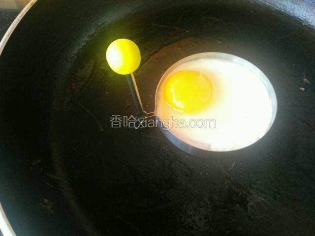平底锅热锅，用刷子刷一点油，煎蛋器边上也刷一点油，将煎蛋器放在锅里，鸡蛋摇一摇打入模具里，小火慢慢煎