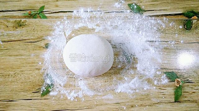 案板上洒适量的面粉 把面团揉下（如图）