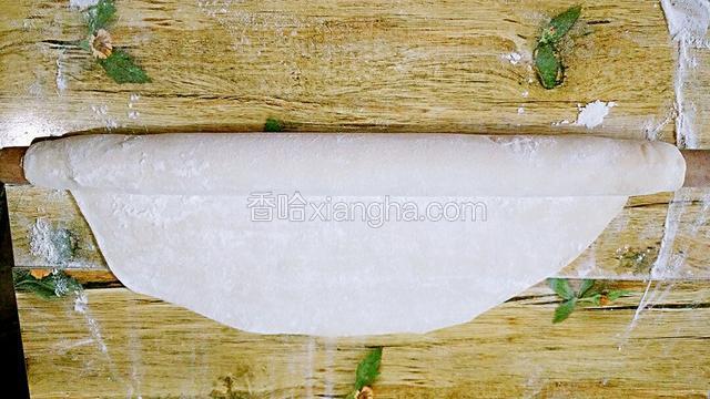 洒上稍微多点的面粉用擀面杖卷起