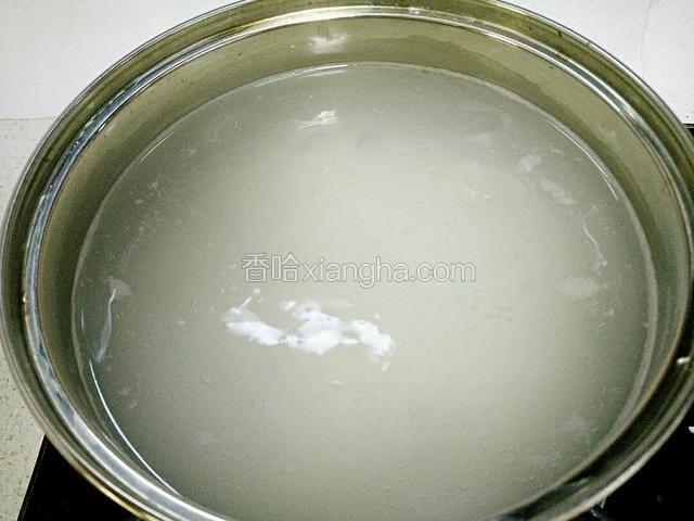 锅里注入适量清水烧开，加入大米。