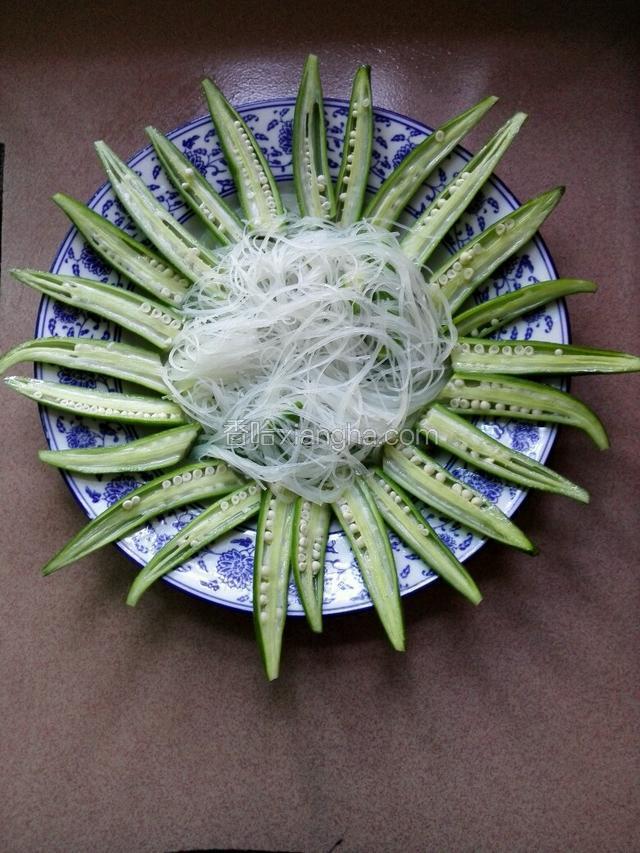 把焯水后秋葵切成两半的摆在盘子四周。