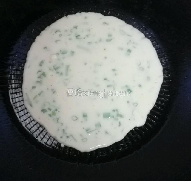 这样就可以烙第一张饼了，提起锅柄转圈，让余下的一丁点油沾匀锅底就好。开小火，放两勺面粉糊