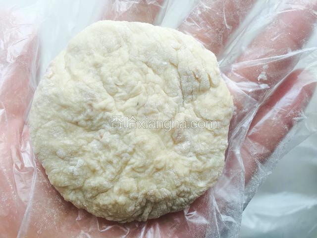 带上一次性手套，把面拍成圆形，放入已经加热后的电饼铛内。