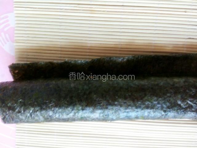 开始卷，卷到最后边缘，手粘水抹在紫菜片上