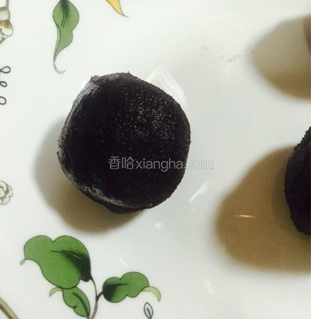把红豆沙馅分成30个大小一致的剂子，用手压成圆片，包住蛋黄，揉圆，盖上保鲜膜备用