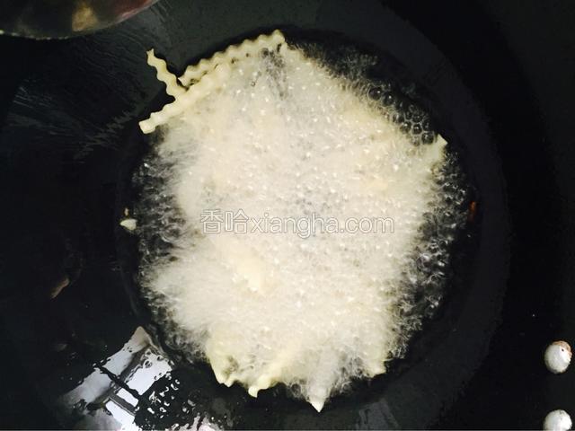 锅里倒油带油温高时，放入狼牙土豆棒，大火油炸，时不时的翻动
