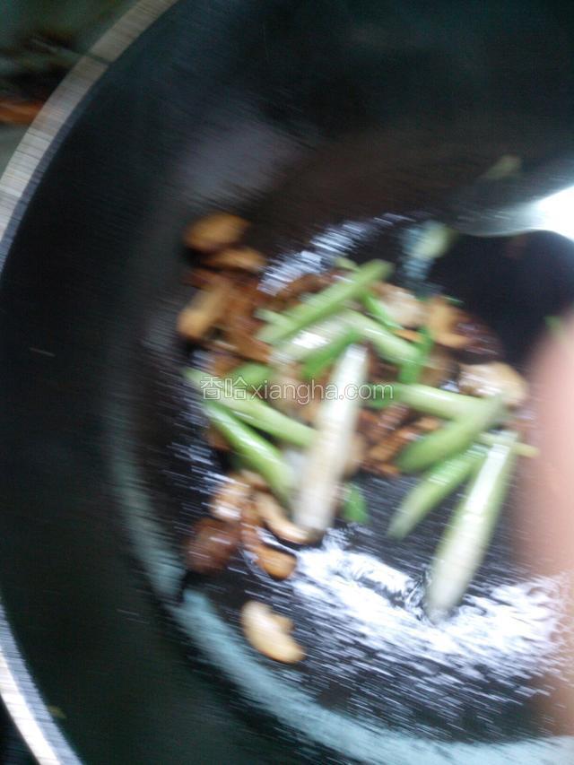 锅内加一点植物油，倒入花菇煸炒一分钟，再倒入青蒜杆炒两分钟，撒一点盐炒匀。