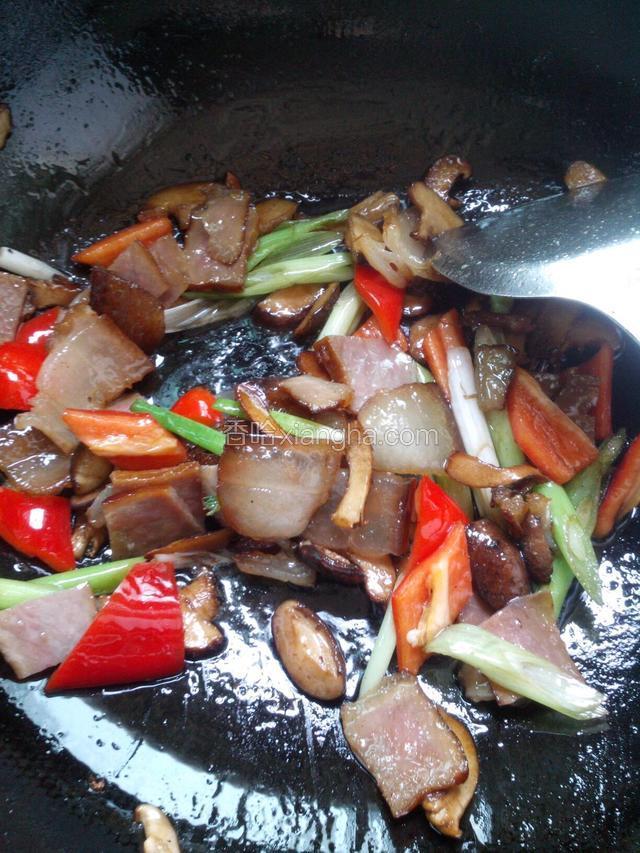 再加入腊肉和红椒片炒两分钟，最后倒入蒜叶炒变软后盛出。自己家炒腊肉，我一般不放味精和酱油的。